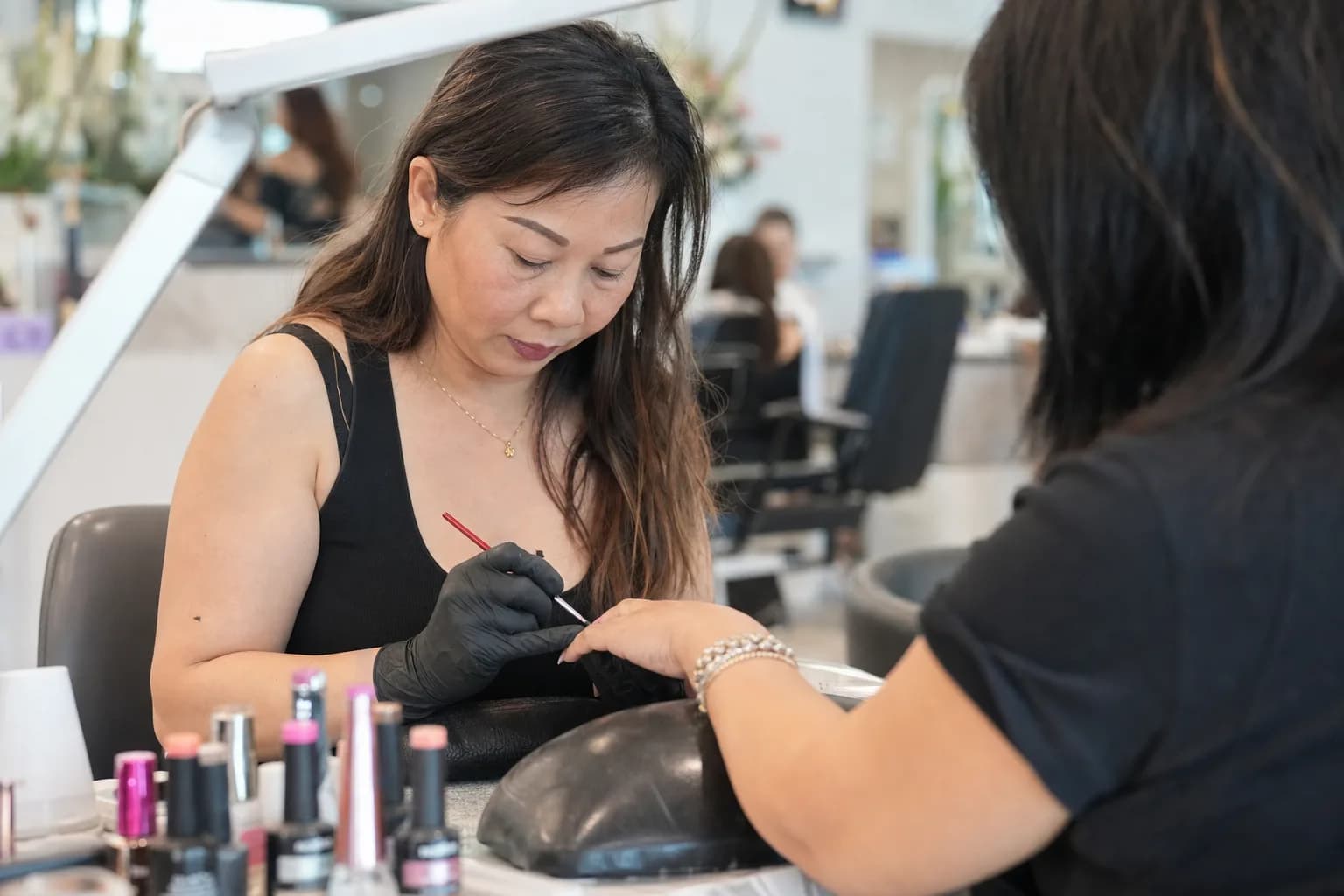Nail technician doing a gel manicure for a client at a Texas nail salon